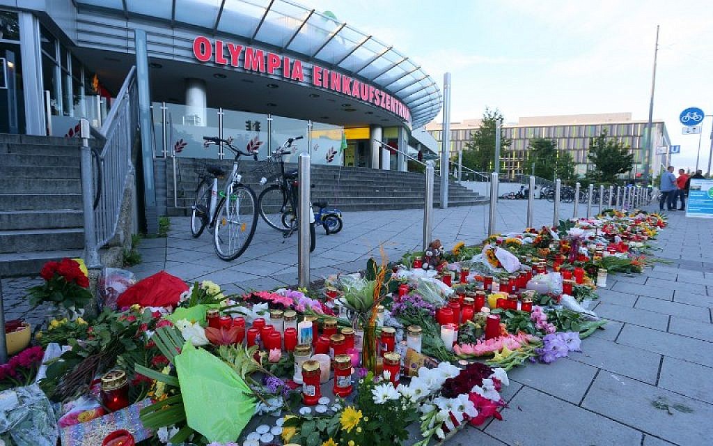 A memorial of candles and flowers stands in front of the Olympia Einkaufszentrum shopping center in Munich, southern Germany, on July 24, 2016, two days after an 18-year-old German-Iranian student killed nine people in a shooting attack there. (AFP PHOTO/dpa/Karl-Josef Hildenbrand)