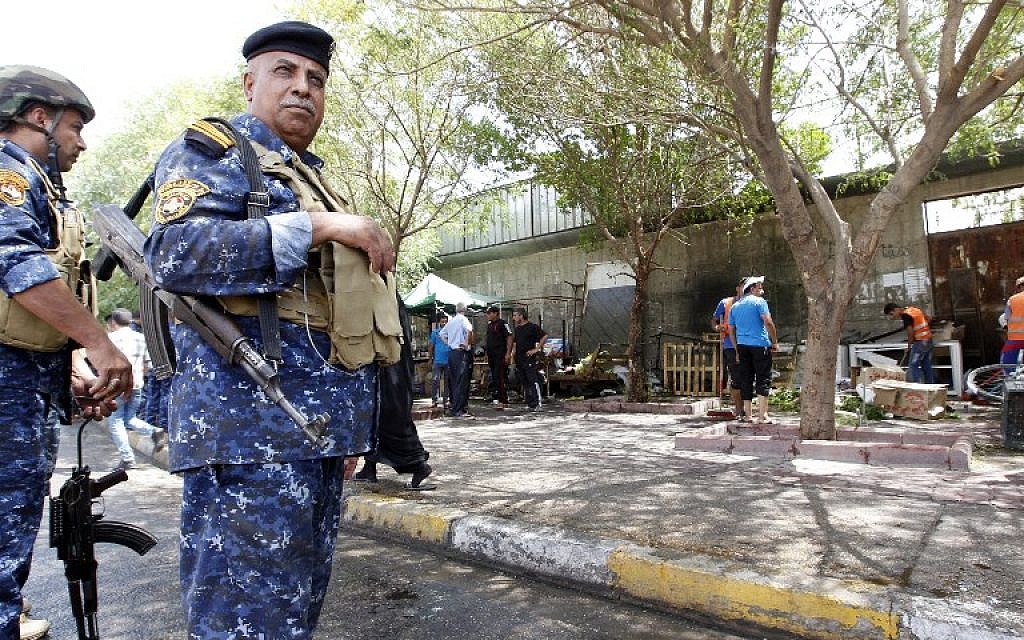 Iraqi security forces stand guard at the site of a suicide bombing on July 24, 2016 near a checkpoint in the Kadhimiyah area, home to a major Shiite shrine, in northern Baghdad. (AFP PHOTO/SABAH ARAR)