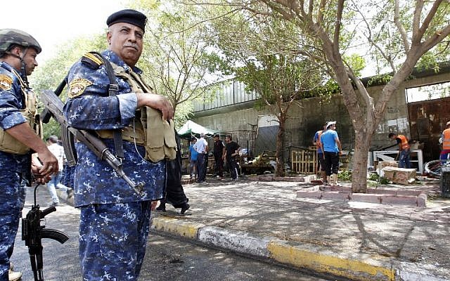 Iraqi security forces stand guard at the site of a suicide bombing on July 24, 2016 near a checkpoint in the Kadhimiyah area, home to a major Shiite shrine, in northern Baghdad. (AFP PHOTO/SABAH ARAR)