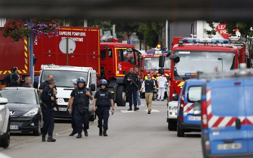 French police officers and firemen arrive at the scene of a hostage-taking at a church in Saint-Etienne-du-Rouvray, northern France, on July 26, 2016 that left the priest dead. (AFP PHOTO/CHARLY TRIBALLEAU)