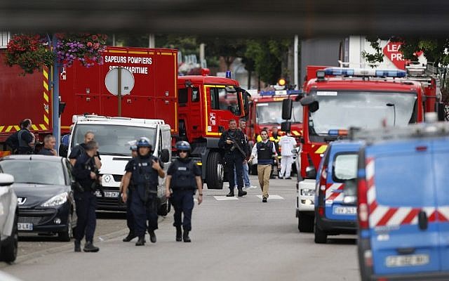 French police officers and firemen arrive at the scene of a hostage-taking at a church in Saint-Etienne-du-Rouvray, northern France, on July 26, 2016 that left the priest dead. (AFP PHOTO/CHARLY TRIBALLEAU)