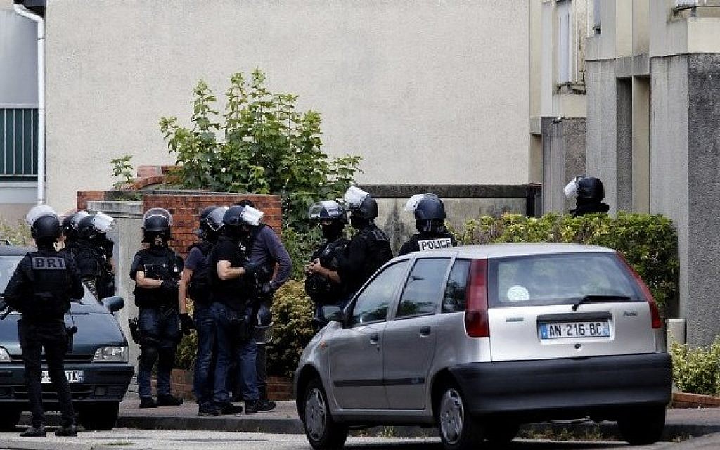 French policemen stand in a street during a search in a house on July 26, 2016 in the Normandy village of Saint-Etienne du Rouvray after a priest was killed in the latest of a string of attacks against Western targets claimed by or blamed on the Islamic State jihadist group.
French President said that two men who attacked a church and slit the throat of a priest had "claimed to be from Daesh", using the Arabic name for the Islamic State group. Police said they killed two hostage-takers in the attack in the Normandy town of Saint-Etienne-du-Rouvray, 125 kilometres (77 miles) north of Paris. / AFP PHOTO / MATTHIEU ALEXANDRE