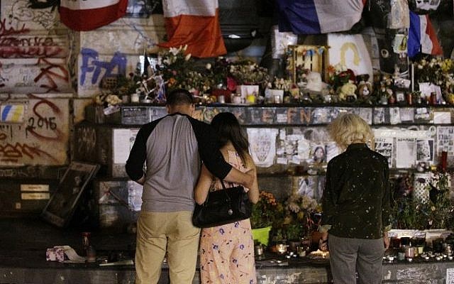 People stand in front of the place de la Republique's monument in Paris, on July 26, 2016 after a priest was killed in the Normandy city of Saint-Etienne-du-Rouvray in the latest of a string of attacks against Western targets claimed by the Islamic State terror group. AFP / GEOFFROY VAN DER HASSELT)