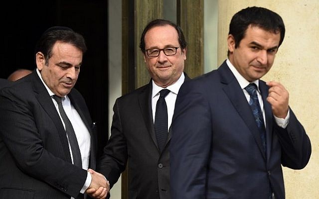 French President Francois Hollande (R) shakes hands with French Jewish central Consistory President Joel Mergui (L) outside the Elysee Palace in Paris, on July 27, 2016 as Ahmet Ogras, vice-president of the French Council of The Muslim Faith leaves after a meeting with French representatives of the different religion following yesterday attack at a church in Saint-Etienne-Du-Rouveray. (AFP PHOTO / BERTRAND GUAY