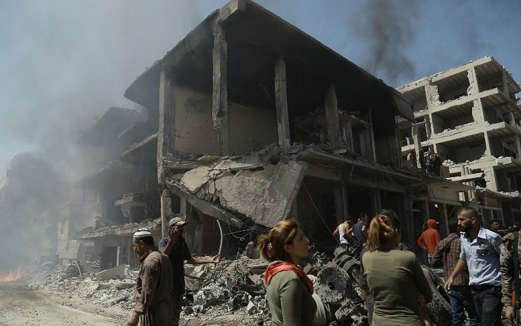 Onlookers gather at the site of a bomb attack in Syria's northeastern city of Qamishli on July 27, 2016.(AFP/Delil Souleiman)