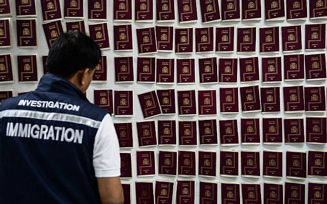 An immigration detective looks at forged Spanish passports at the Immigration Detention Center in Bangkok on July 22, 2016. (AFP PHOTO/LILLIAN SUWANRUMPHA) An immigration detective looks at forged Spanish passports at the Immigration Detention Center in Bangkok on July 22, 2016. (AFP PHOTO/LILLIAN SUWANRUMPHA)