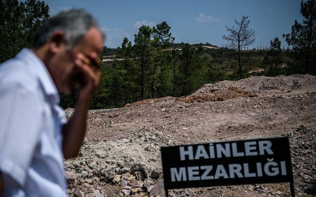 A man stands at 'Traitors' Cemetery,' dug by Istanbul municipality for soldiers killed as they carried out a failed plot to overthrow President  Recep Tayyip Erdogan, on July 28, 2016. (AFP PHOTO/OZAN KOSE)