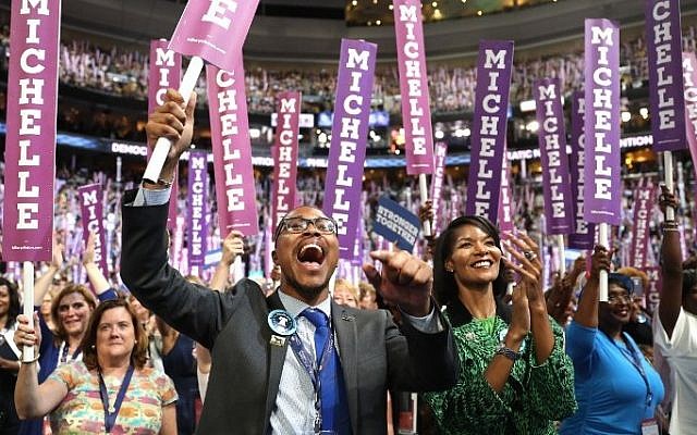 Delegates stand and cheer as first lady Michelle Obama delivers remarks on the first day of the Democratic National Convention at the Wells Fargo Center, July 25, 2016 in Philadelphia, Pennsylvania. (Joe Raedle/Getty Images/AFP)