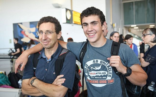 IDF recruit Aviad Karmazyn saying goodbye to his father before boarding a Nefesh B'Nefesh chartered flight to Israel from New York, July 18, 2016. (Shahar Azran)