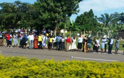 Ugandans wave and hold Israeli flags near Entebbe Airport as the Israeli delegation passes, July 4, 2016 (Raphael Ahren / Times of Israel)