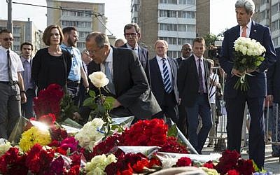 US Secretary of State John Kerry, right, and Russian Foreign Minister Sergey Lavrov, center, lay flowers at the French Embassy in Moscow, Russia on July 15, 2016, to pay condolences to victims of Thursday's terrorist attack in Nice, France. (AP Photo/Pavel Golovkin)
