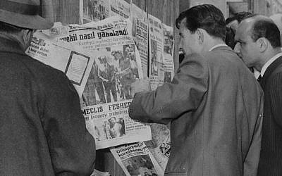 In this May 28, 1960 photo, citizens stand at a newsstand read of the capture of Prime Minister Adnan Menderes after a military coup, in Istanbul, Turkey. (AP Photo)