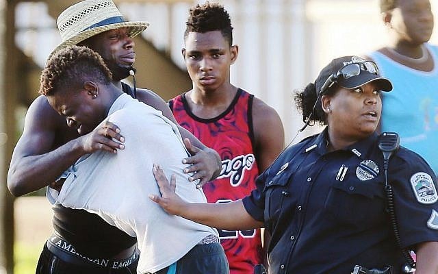 People embrace after a fatal shooting at Club Blu in Fort Myers, Florida, Monday, July 25, 2016. (Kinfay Moroti/The News-Press via AP)