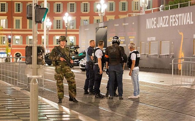 Police officers and a soldier stand by the sealed off area of a terror attack after a truck drove onto the sidewalk and plowed through a crowd of revelers who'd gathered to watch the fireworks in the French resort city of Nice, southern France, Friday, July 15, 2016. (AP Photo/Ciaran Fahey)