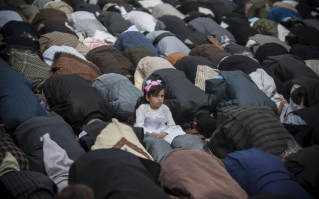 A girl sits between Yemeni worshippers attending Eid al-Fitr prayers that mark the end of the holy fasting month of Ramadan, in Sanaa, Yemen, Wednesday, July 6, 2016. (AP Photo/Hani Mohammed)