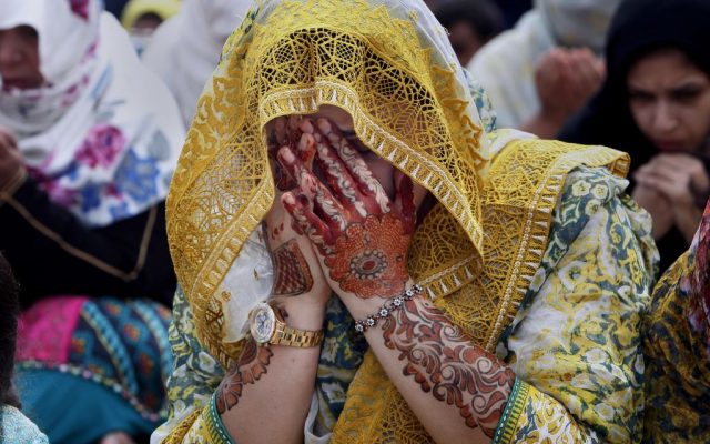 A Pakistani woman prays during Eid al-Fitr prayers at the historical Badshahi mosque in Lahore, Pakistan, Wednesday, July 6, 2016. b(AP Photo/K.M. Chaudary)