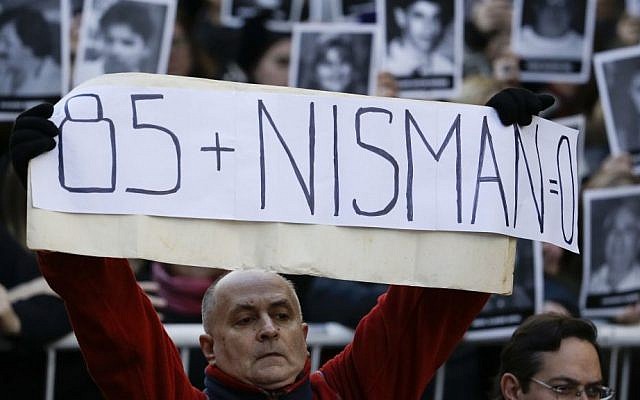 A man holds a sign that reads in Spanish: "Eighty-five plus Nisman equals zero" on the 22nd anniversary of the bombing of the AMIA Jewish center that killed 85 people in Buenos Aires, Argentina, Monday, July 18, 2016. (AP Photo/Natacha Pisarenko) 