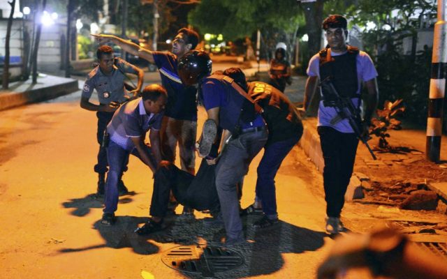 People help an unidentified injured person after a group of gunmen attacked a restaurant popular with foreigners in a diplomatic zone of the Bangladeshi capital Dhaka, Bangladesh, Friday, July 1, 2016. (AP) People help an unidentified injured person after a group of gunmen attacked a restaurant popular with foreigners in a diplomatic zone of the Bangladeshi capital Dhaka, Bangladesh, Friday, July 1, 2016. (AP)