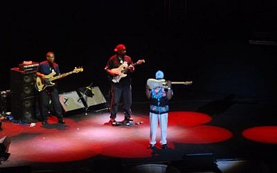 Buddy Guy playing the guitar with his teeth. (Miriam Nahum/Times of Israel)