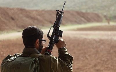 Illustrative: An IDF soldier holding a weapon. (Yaakov Naumi/Flash90)