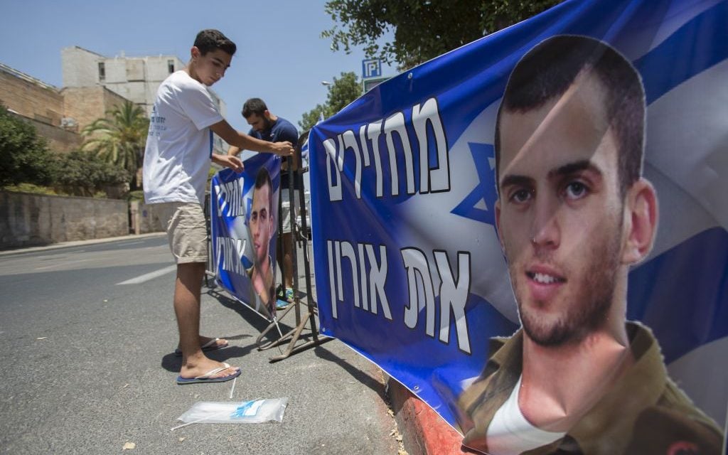 Brother of late Israeli soldier Oron Shaul seen at a protest tent outside the Prime Minister Benjamin Netanyahu's residence in Jerusalem on June 30, 2016. The sign reads 'Returning Oron.' (Photo by Yonatan Sindel/Flash90)