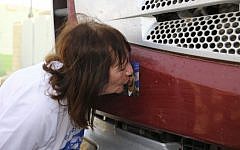 The mother of fallen Israeli soldier Oron Shaul kisses a photo of her son at the Erez crossing in southern Israel, near the Gaza Strip on July 3, 2016 (Flash90)