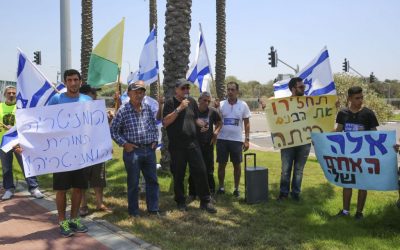 Friends and family of an Israeli soldier whose remains are being held by Hamas protest outside the Ashdod port in southern Israel on July 3, 2016, as the Lady Leyla, a Turkish ship carrying aid for Gaza, arrives (Flash90)
