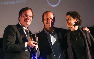 American filmmaker and actor Quentin Tarantino (left) receiving an award from Jerusalem Mayor Nir Barkat (center) and Jerusalem Cinematheque director Noa Regev (right) at the opening night of the Jerusalem Film Festival, on July 7, 2016. (Hadas Parush/Flash90)