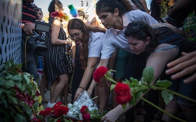 Participants lay flowers at the site where Shira Banki was stabbed to death at last year's Pride Parade, during the annual parade in Jerusalem attended by more than 25,000, on July 21, 2016. (Hadas Parush/Flash90)