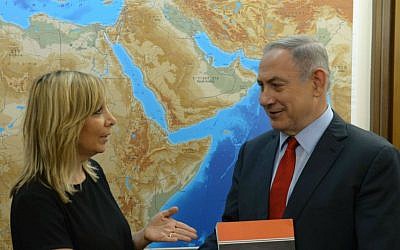 Prime Minister Benjamin Netanyahu, right, receives the report of the Palmor Committee to eradicate racism against Ethiopian Israelis, from the hands of Justice Ministry Director General Emi Palmor at the Prime Minister's Office in Jerusalem, July 31, 2016. (Amos Ben Gershom/GPO)