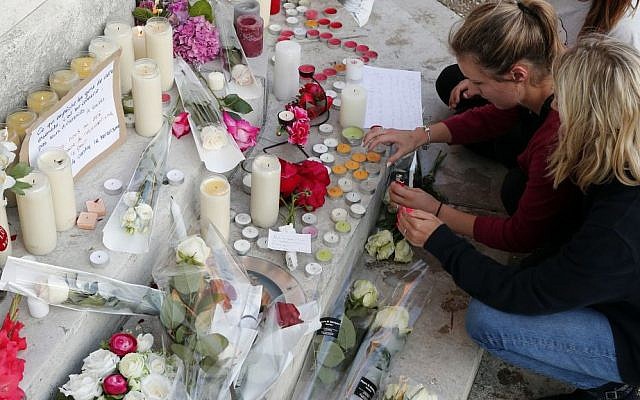 Flowers, candles and messages are placed on the city hall entrance closed to the home of Father Jacques Hamel after he was killed during an attack in a church in Saint-Etienne-du-Rouvray, Normandy, France, Tuesday, July 26, 2016. (AP Photo/Francois Mori) 