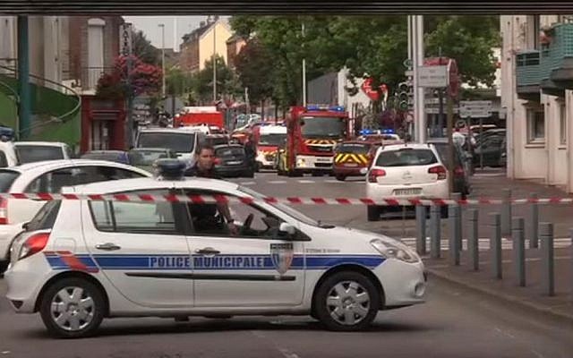In this grab made from video, police officers close off a road during a hostage situation in Normandy, France, Tuesday, July 26, 2016. (BFM via AP)