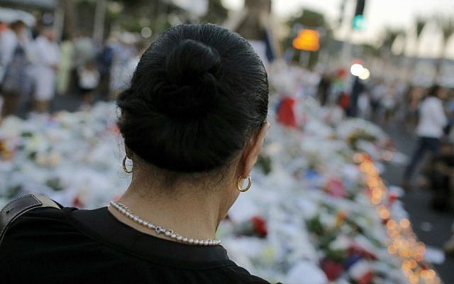 A woman pays tribute to the victims of a deadly terror attack at the site on the famed Boulevard des Anglais in Nice, southern France, Saturday, July 16, 2016. (AP Photo/Laurent Cipriani)