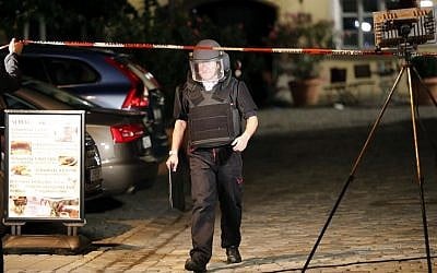 A special police officer leaves the area where an assylum seeker blew himself up in Ansbach, Germany, Monday, July 25, 2016. (AP Photo/Matthias Schrader)