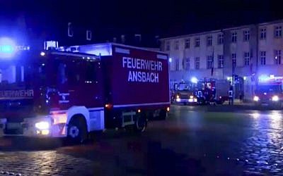 In this image taken from video, fire trucks and ambulances stand in the city center of Ansbach near Nuremberg, southern Germany, Monday morning, July 25, 2016, after a man was killed when an explosive device he was believed to be carrying went off near an open-air music festival, injuring 12 others. (News5 via AP)