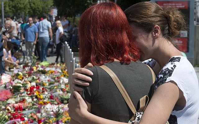 People mourn beside the Olympia shopping center where a shooting took place leaving nine people dead in Munich, Germany, Sunday, July 24, 2016. (AP/Jens Meyer) People mourn beside the Olympia shopping center where a shooting took place leaving nine people dead in Munich, Germany, Sunday, July 24, 2016. (AP/Jens Meyer)