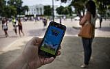 A man holds up his cellphone with a screenshot of the Pokemon Go game in front of the White House in Washington, DC, July 12, 2016. (JIM WATSON/AFP/Getty Images)