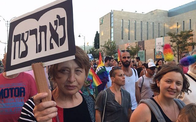 A woman holds a sign saying, 'Thou Shalt Not Murder,' at Jerusalem gay pride parade on July 21, 2016 (Times of Israel)