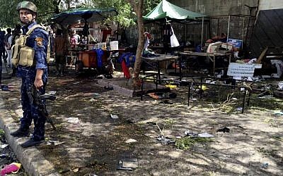 Iraqi security forces and civilians gather at the scene of a bomb in Kadhimiyah district, Baghdad, Iraq, Sunday, July 24, 2016. (AP Photo/Ali Abdul Hassan)