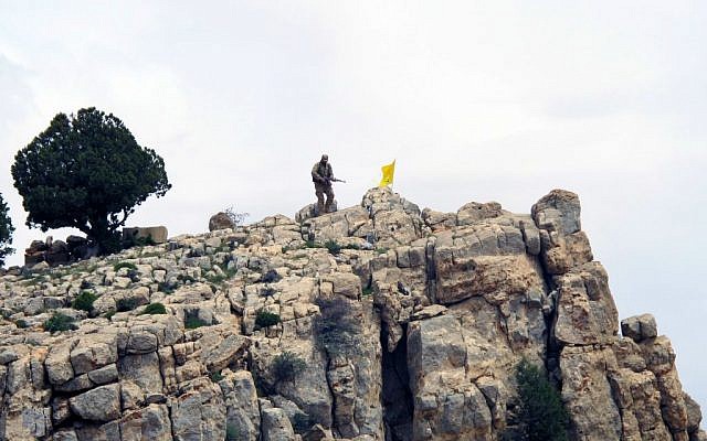In this Saturday, May 9, 2015 photo, a Hezbollah fighter stands on a hill next to the group's yellow flag in the fields of the Syrian town of Assal al-Ward in the mountainous region of Qalamoun, Syria. (AP Photo/Bassem Mroue, File) In this Saturday, May 9, 2015 photo, a Hezbollah fighter stands on a hill next to the group's yellow flag in the fields of the Syrian town of Assal al-Ward in the mountainous region of Qalamoun, Syria. (AP Photo/Bassem Mroue, File)