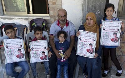 Nasser Tarayrah, center, and his wife Raeda, second right, parents of Palestinian terrorist Muhammad Tarayrah, who murdered Hallel Ariel on June 30, 2016 as she slept in her home in Kiryat Arba, pose for a picture with some of their children, in the West Bank village of Bani Na'im, near Hebron, July 9, 2016 (AP Photo/Nasser Nasser)