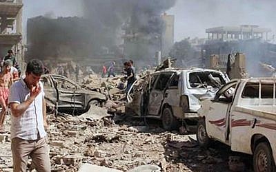 In this photo released by the Syrian official news agency SANA, Syrians inspect damages after twin bombings struck Kurdish town of Qamishli, Syria, Wednesday, July 27, 2016. (SANA via AP)