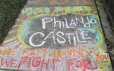 A chalk tribute to Philando Castile marked a sidewalk across the street from the Minnesota governor's residence as demonstrators gathered outside the residence Friday, July 8, 2016, in St. Paul, Minnesota, to protest the shooting death by police of Castile after a traffic stop Wednesday, July 6, in nearby Falcon Heights. (AP Photo/Jim Mone)