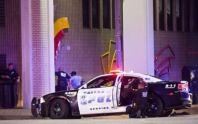 Dallas Police shield bystanders during a Black Lives Matter rally in downtown Dallas on Thursday, July 7, 2016. Multiple media outlets report that shots were fired Thursday night during a Dallas protest over two recent fatal police shootings of black men. (Smiley N. Pool/The Dallas Morning News via AP) 