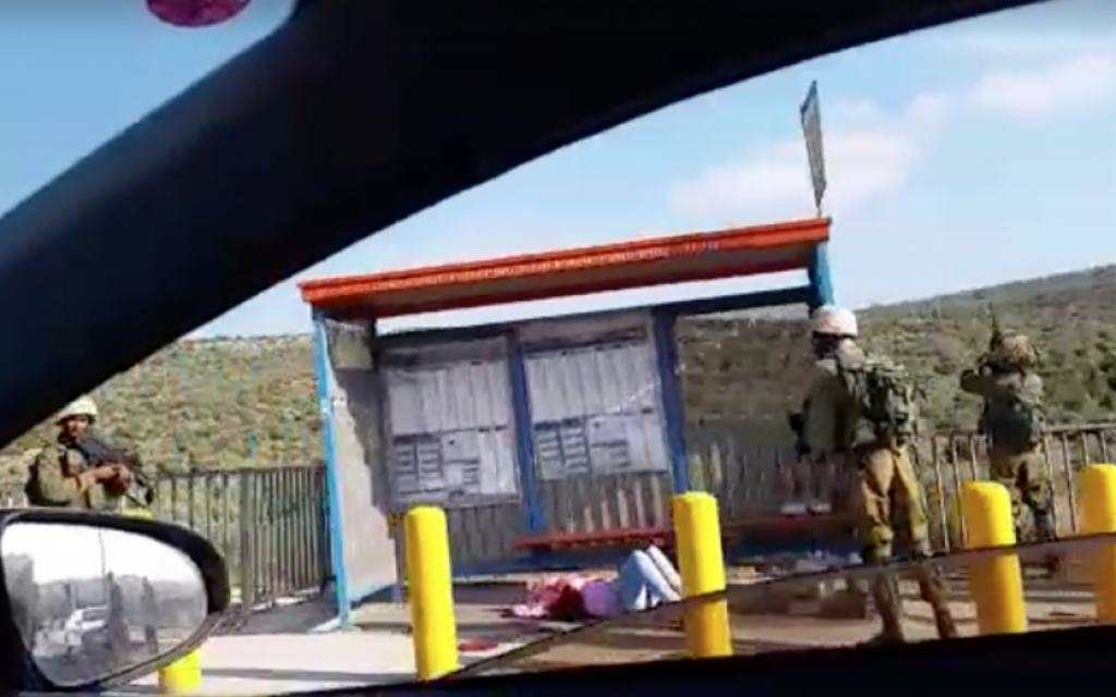 A Palestinian woman bleeds on the floor of a bus stop outside of Ariel in the West Bank after she was shot while allegedly trying to stab IDF soldiers on July 5, 2016. (Screen capture: Dina Cohen)