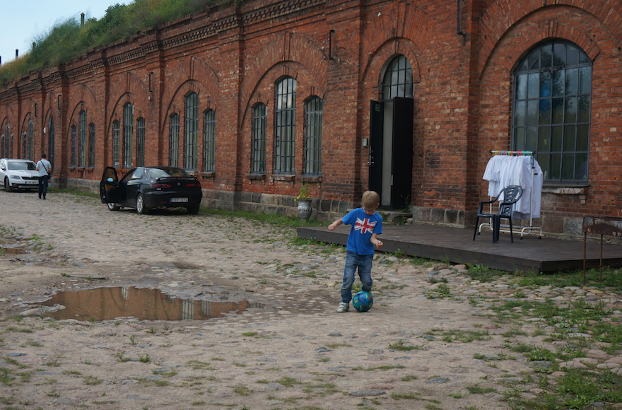 A boy playing soccer at the entrance to the former concentration camp known as the Seventh Fort in Kaunas, Lithuania, July 12, 2016. (Cnaan Liphshiz) A boy playing soccer at the entrance to the former concentration camp known as the Seventh Fort in Kaunas, Lithuania, July 12, 2016. (Cnaan Liphshiz)