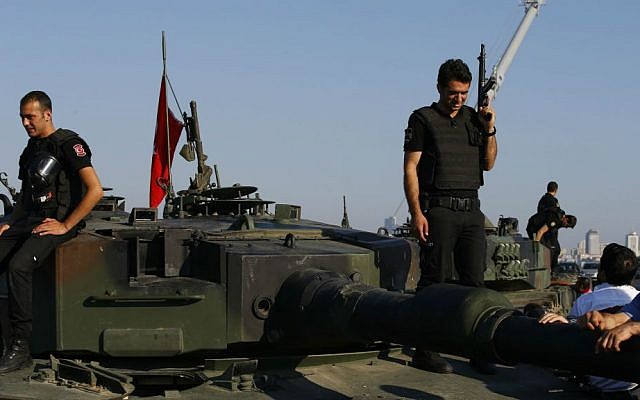Turkish police officers, loyal to the government, stand atop tanks abandoned by Turkish army officers near Istanbul's iconic Bosporus Bridge, Saturday, July 16, 2016. (AP Photo/Emrah Gurel)
