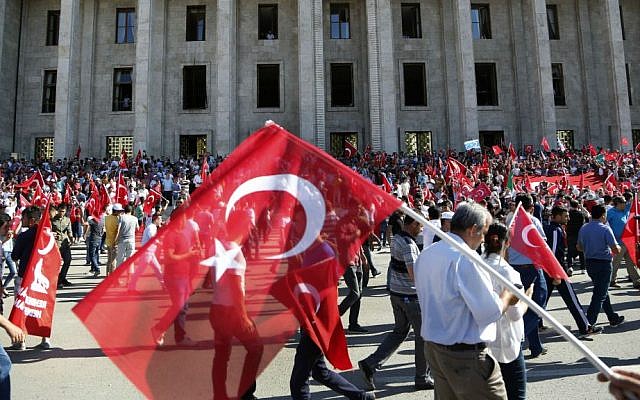 Turkish citizens wave their national flag as they protest against the military coup outside Turkey's parliament, near Turkish military headquarters in Ankara, Turkey, Saturday, July 16, 2016. (AP Photo/Hussein Malla)