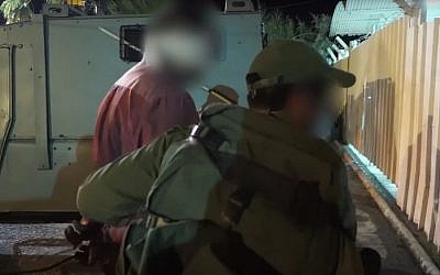 IDF troops detain a man during a July 27, 2016 raid in the West Bank to arrest a Hamas cell behind the murder of Rabbi Miki Mark (screen capture: YouTube)