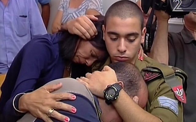 Elor Azaria hugging his mother and father in Jaffa military court on July 5, 2016. (screen capture: Channel 2)